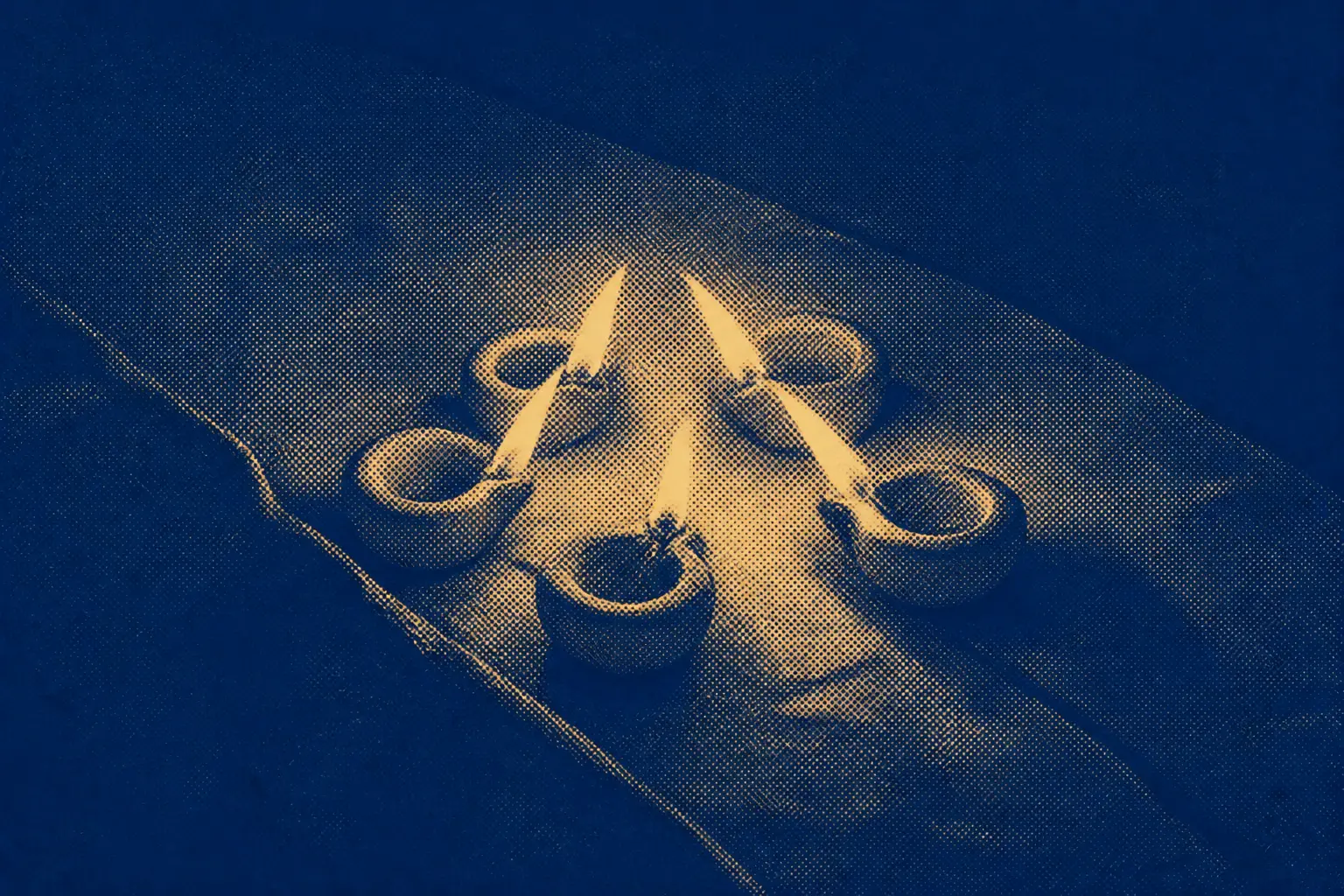 Several small clay oil lamps burning together on a dark stone ledge, their flames leaning toward one another.
