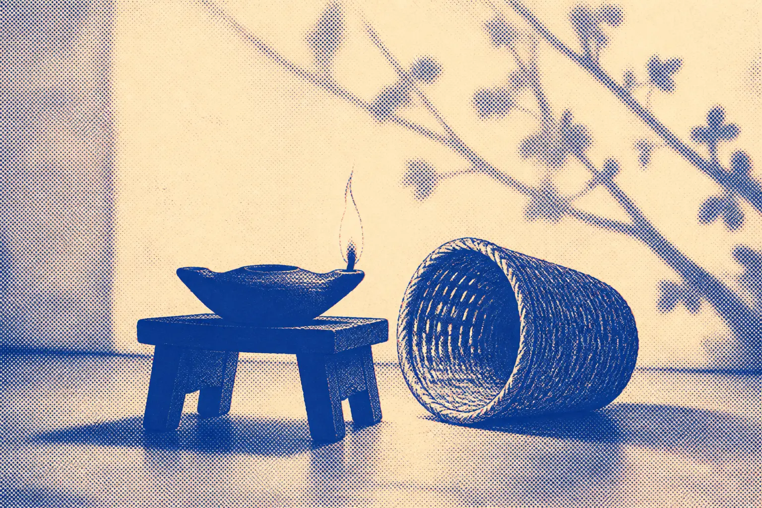 A simple wooden lampstand with a lit clay oil lamp on top, and a woven reed basket lying on its side on the floor nearby, clearly set down and out of use